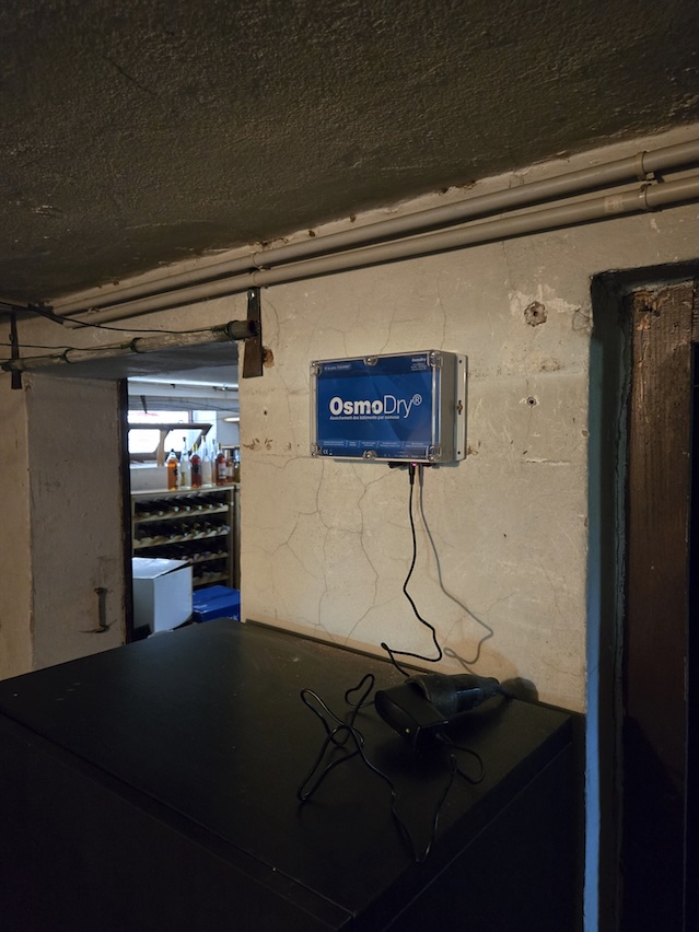 Boîtier OsmoDry® installé dans une cave avec vins