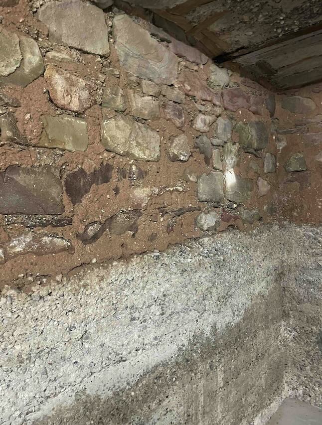 Mur en pierres dégradé par l'humidité — salpêtre visible